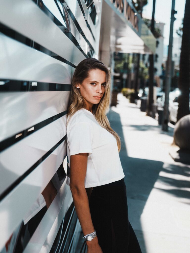 IMG model Evelyn Rose leaning against modern storefront on Rodeo Drive Beverly Hills captured in natural light editorial style by photographer Johnny Hann